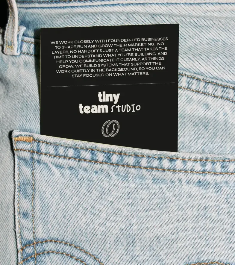 A black card printed with the wordmark tucked into the back pocket of a pair of jeans