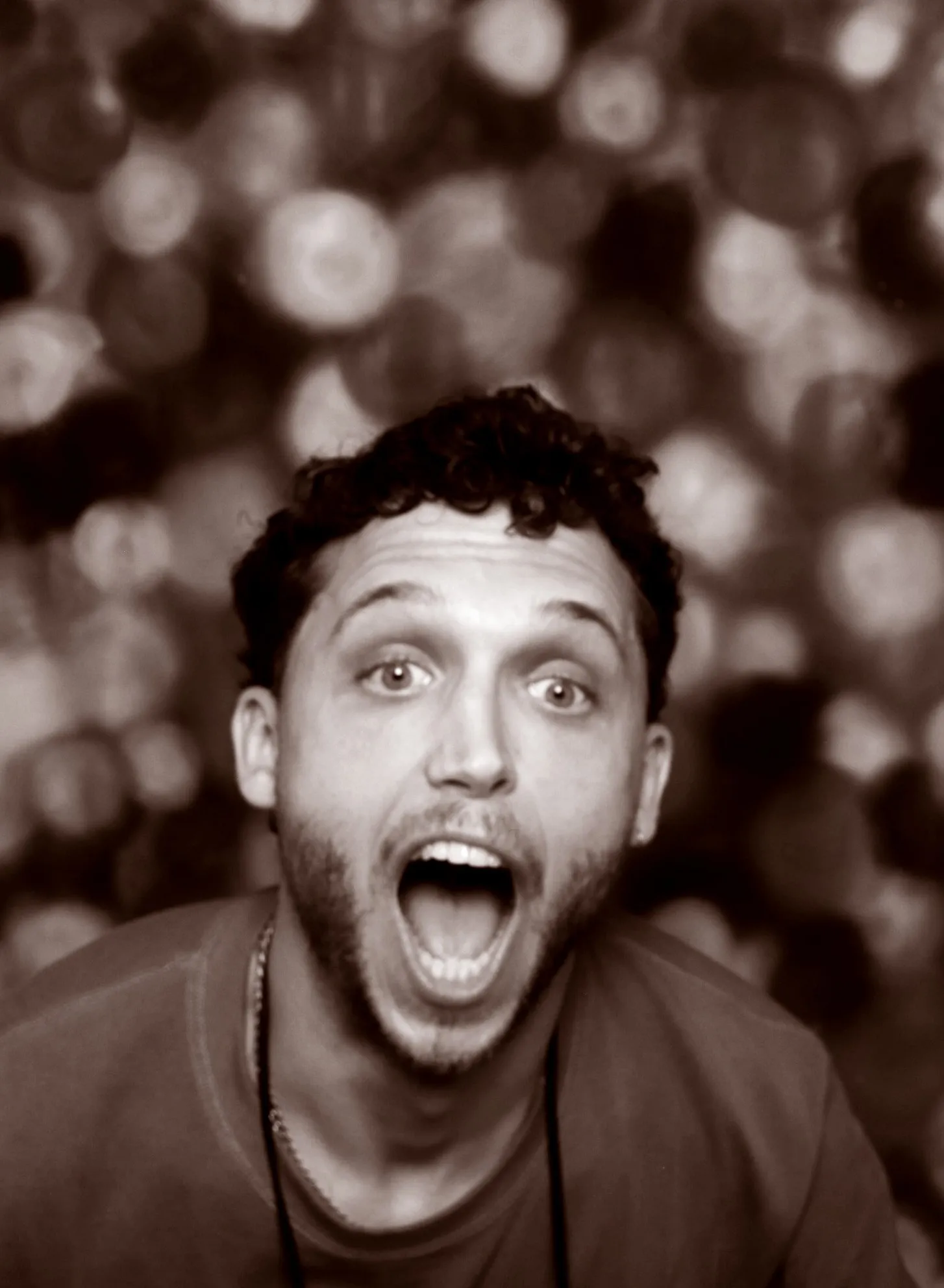 James, caught mid-shout, in a photo-booth portrait