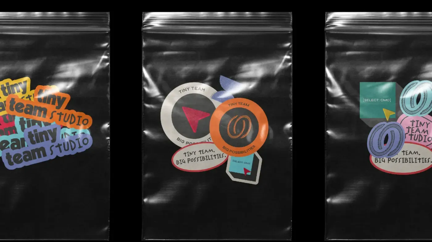 Three foil packets of studio stickers laid out on black